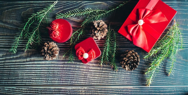 Weihnachtsdekorationszusammensetzung auf hölzernem Hintergrund mit einer schönen roten Geschenkbox