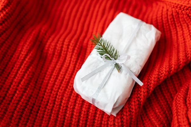 Weihnachtsdeutsches Gebäck mit einem schönen Band und einem Nobilis-Zweig auf rotem Hintergrund Traditionelles Weihnachtsdessert Stollen zu Weihnachten