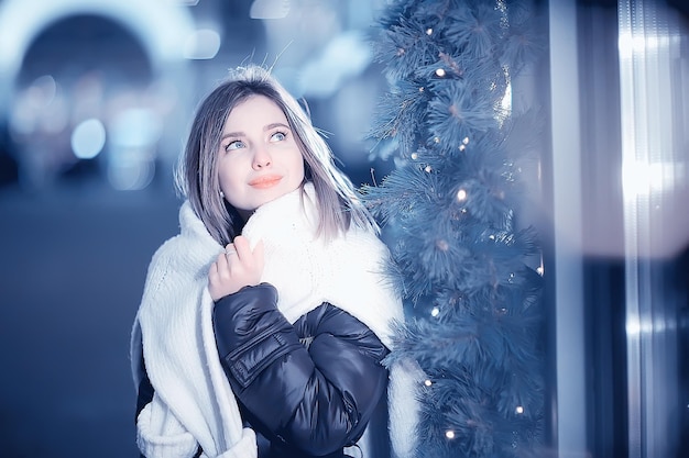 Weihnachtseinkaufsmädchenstadt, junges vorbildliches abendliches Geschenkeeinkaufen, saisonaler Verkauf, Winterabend draußen in der Stadt