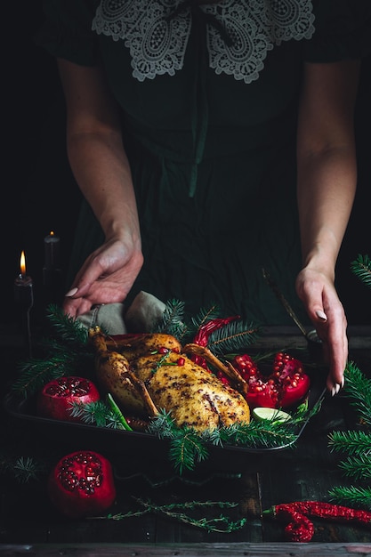 Weihnachtsente mit Granatäpfeln und Kalk, umgeben von Fichtenzweigen