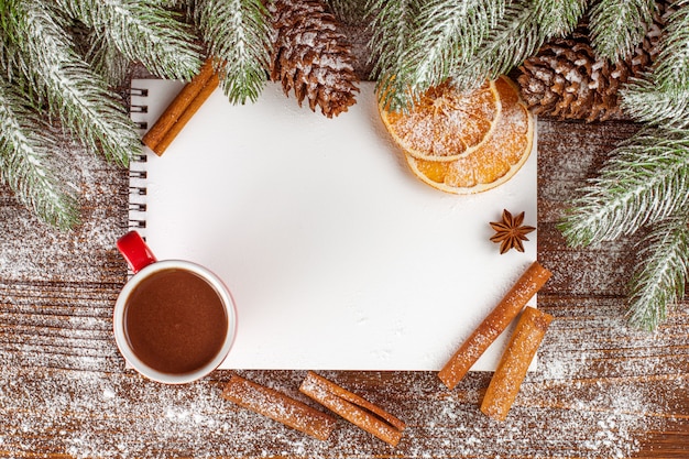 Weihnachtsfahne mit grünem Baum, Zapfen, roten Tassen mit heißer Schokolade, Orange und Zimt.