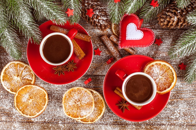 Weihnachtsfahne mit grünem Baum, Zapfen, roten Tassen mit heißer Schokolade, Orange und Zimt.