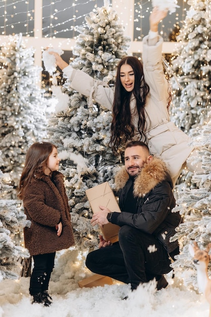 Weihnachtsfamilienporträtfamilie nahe schönen Weihnachtsbäumen