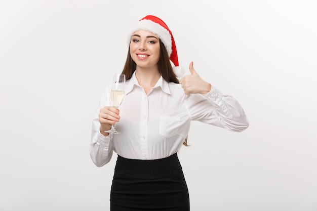 Weihnachtsfeier junge schöne Geschäftsfrau, die Weihnachten mit Glas Champagner feiert und Daumen oben zeigt