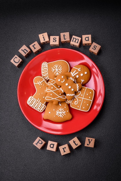 Foto weihnachtsfeierinschrift mit holzwürfeln auf einem dunklen beton-hintergrund