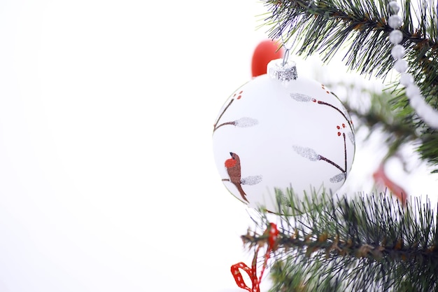 Weihnachtsfeiertag-Hintergrund. Silber- und Farbflitter, der von einem verzierten Baum mit Bokeh und Schnee hängt, Kopienraum.