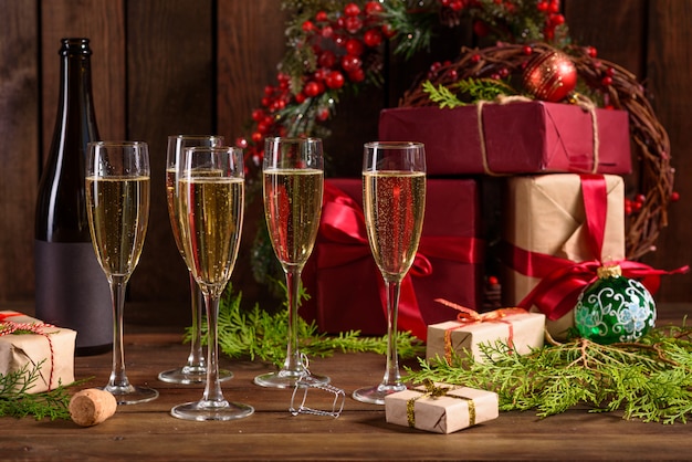 Weihnachtsfeiertagstabelle mit Gläsern und einer Flasche Wein Champagner