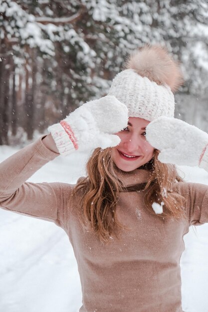 Foto weihnachtsferien und jahreszeit konzept junge glückliche frau blasen schnee in der winter-wald-natur