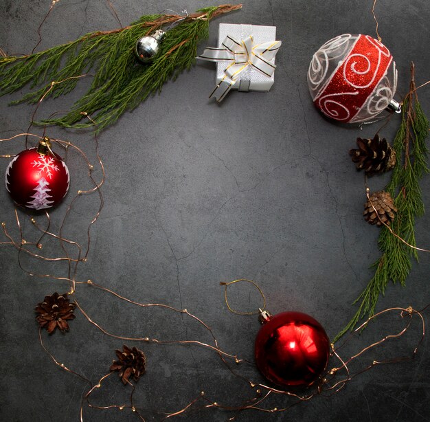 Weihnachtsferienkompositionshintergrund, festliche Lichter, rote Kugeln und Wacholderzweige