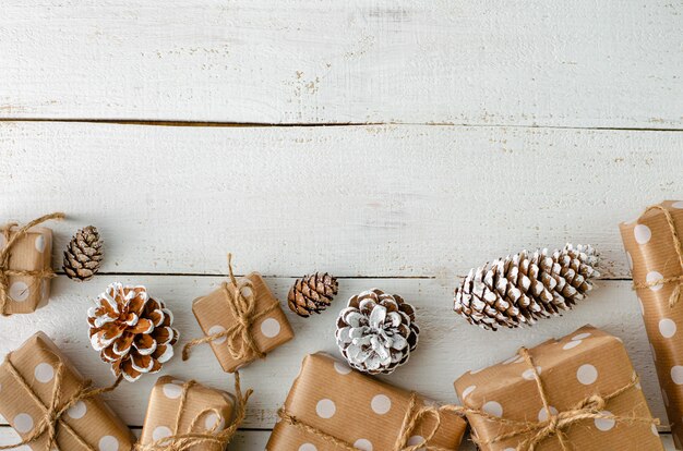 Weihnachtsfestliche decotrations mit Geschenkboxen und Kegeln auf weißem hölzernem Hintergrund