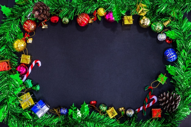 Weihnachtsfestliche Dekorationen mit leerem auf schwarzem Papierhintergrund, Konzept des neuen Jahres.