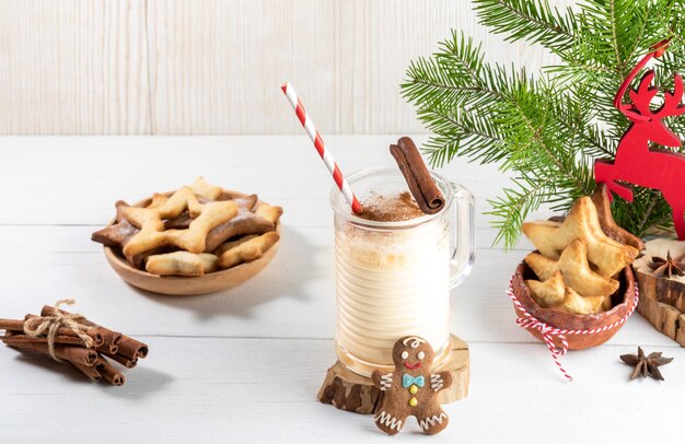 Foto weihnachtsfestliche komposition mit traditionellem wintergetränk eiernog mit ingwerkekse auf weiß