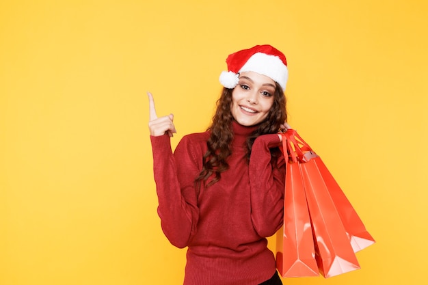 Weihnachtsfrau im Weihnachtsmannhut, der große Tasche mit Geschenken lokalisiert hält