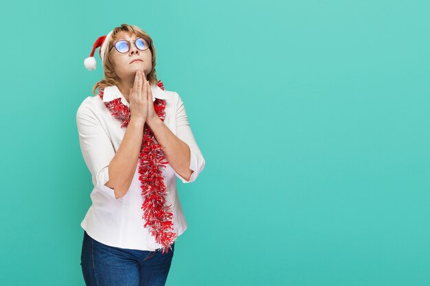 Weihnachtsfrau in weißem Hemd und Jeans auf blauem Hintergrund