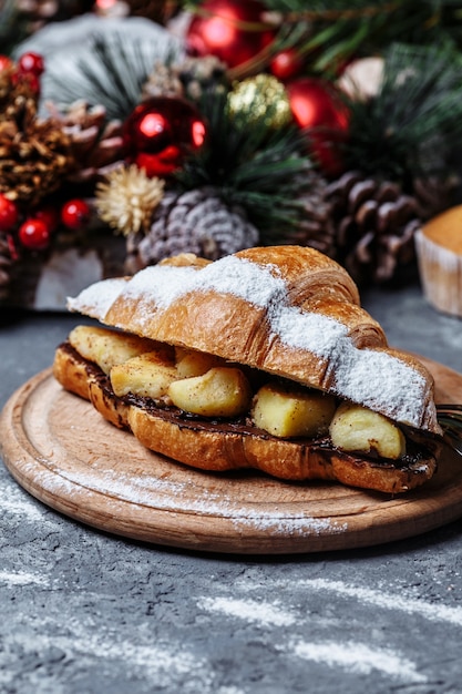 Weihnachtsfrühstück mit Croissants. Weihnachtscroissant mit Schokolade und gebackener Ananas.