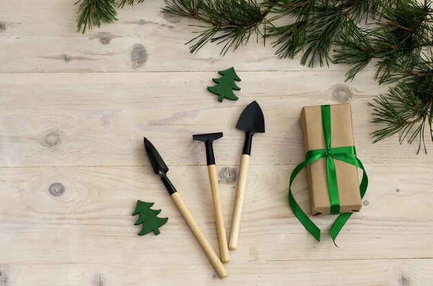 Weihnachtsgartengeräte auf weißem Holztisch Draufsicht flach