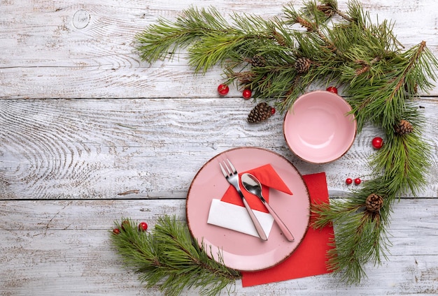 weihnachtsgedeck auf hellem holztisch draufsicht mit weihnachtsbaum