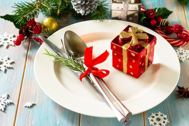 Weihnachtsgedeck Festlicher Teller und Besteck mit Dekor auf festlichem Tisch