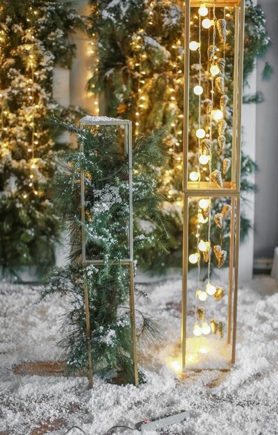 Weihnachtsgelb leuchtende Glühbirnen auf einem grünen Baumhintergrund