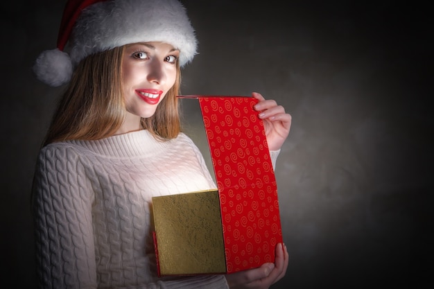 Weihnachtsgeschenk.Ferienzauber. Glückliches Mädchen öffnet eine Geschenkbox