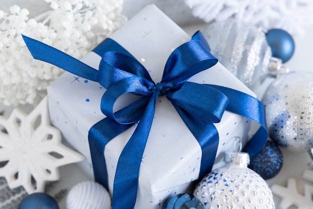 Weihnachtsgeschenk mit blauer Schleife und silberner Dekoration Nahaufnahme