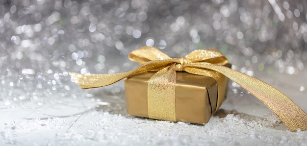 Weihnachtsgeschenkbox auf abstrakten Bokeh-Lichtern und Glitzerhintergrund