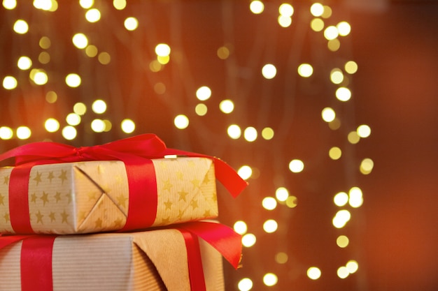 Weihnachtsgeschenkbox auf holztisch gegen braunen bokeh hintergrund