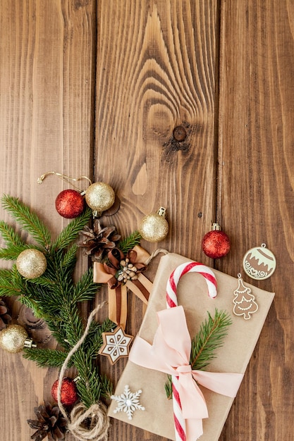 Weihnachtsgeschenkbox-Dekor und Tannenzweig auf Holztisch Draufsicht mit Kopierraum