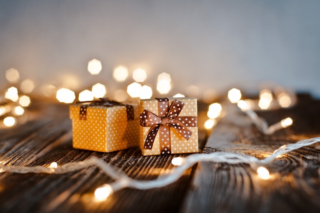 Weihnachtsgeschenkbox lag auf einem Holztisch auf einem bokeh von festlichen Lichtern.