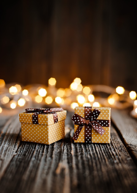 Weihnachtsgeschenkbox legen Holztisch bokeh festliche Lichter.