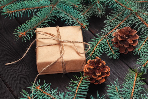 Weihnachtsgeschenkboxen und Tannenbaumast auf Holztisch.