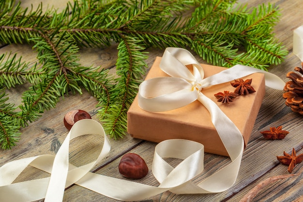 Weihnachtsgeschenkboxen und Tannenbaumast auf Holztisch.