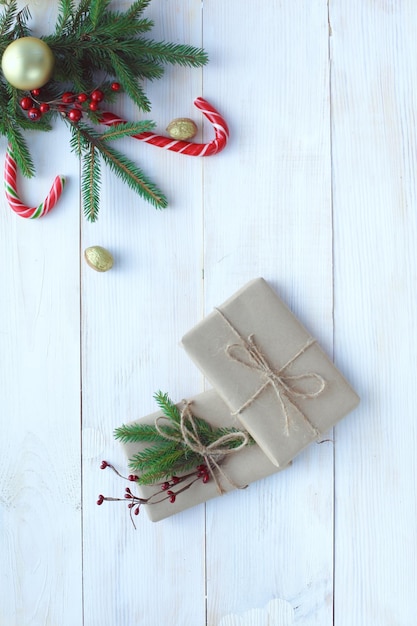 Weihnachtsgeschenkboxen und Tannenzweig auf Holztisch flach legen Shristmas Hintergrund