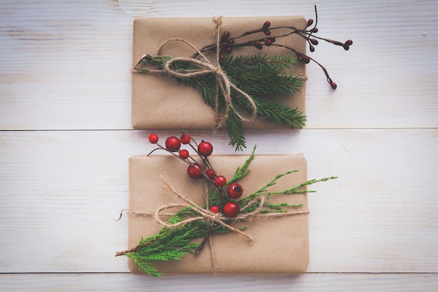 Weihnachtsgeschenkboxen und Tannenzweig auf Holztisch flach legen Shristmas Hintergrund