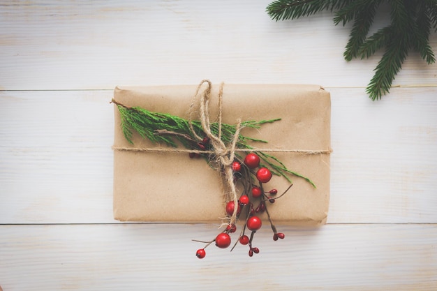 Weihnachtsgeschenkboxen und Tannenzweig auf Holztisch flach legen Shristmas Hintergrund