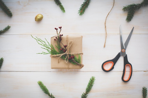 Weihnachtsgeschenkboxen und Tannenzweig auf Holztisch flach legen Shristmas Hintergrund