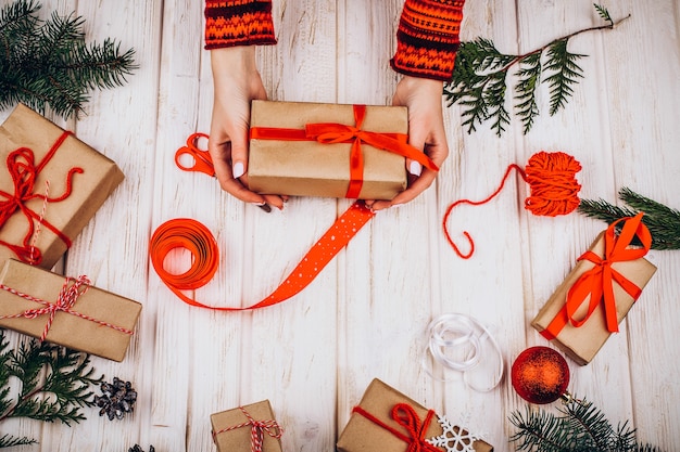 Weihnachtsgeschenke im braunen Papier mit roten Bändern liegen auf dem Tisch