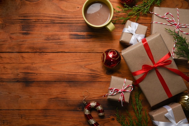 Weihnachtsgeschenke und heiße Tasse Kaffee auf Holzuntergrund. Weihnachts- und Neujahrskonzept.