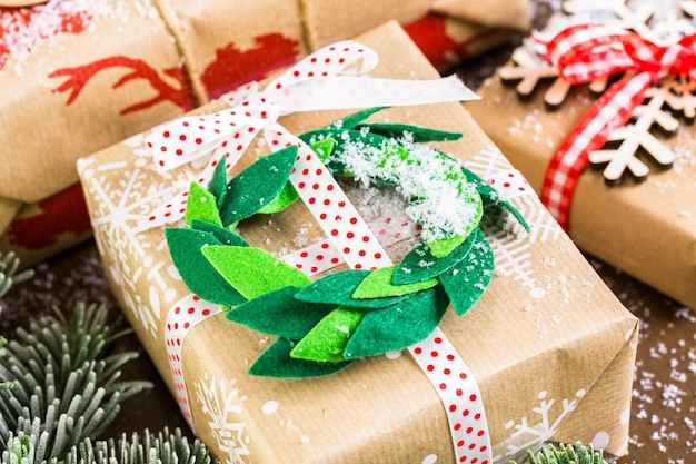 Weihnachtsgeschenke verpackt in braunem Papier mit roten Bändern.