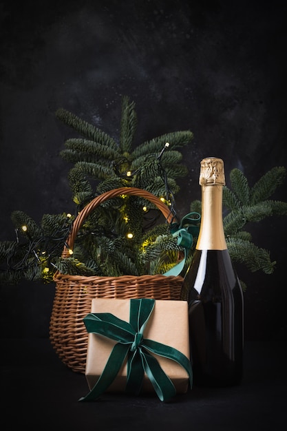 Weihnachtsgeschenkkorb mit Bastelgeschenk und Sekt auf Schwarz.