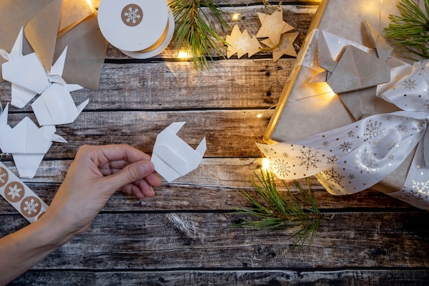 Foto weihnachtsgeschenkte geschenkbox mit origami-papierstier. symbol 2021. anleitung schritt für schritt. flache lage, draufsicht