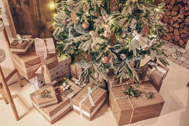 Weihnachtsgeschmückter Baum und stilvolle Öko-Geschenkboxen aus Kraftpapier