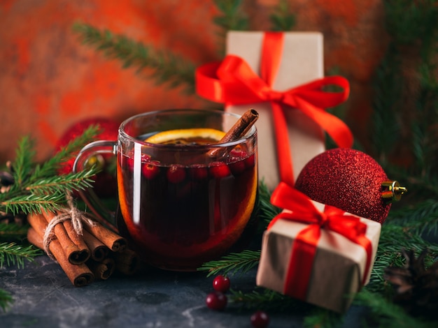 Weihnachtsgetränk Glühwein in einer Glasschale auf dem Tisch mit Zweigen Fichte