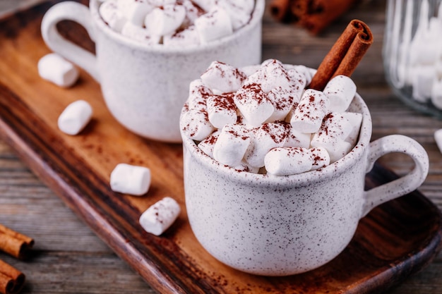Weihnachtsgetränk Heiße Schokolade mit Marshmallows und Zimt auf dunklem Holzhintergrund