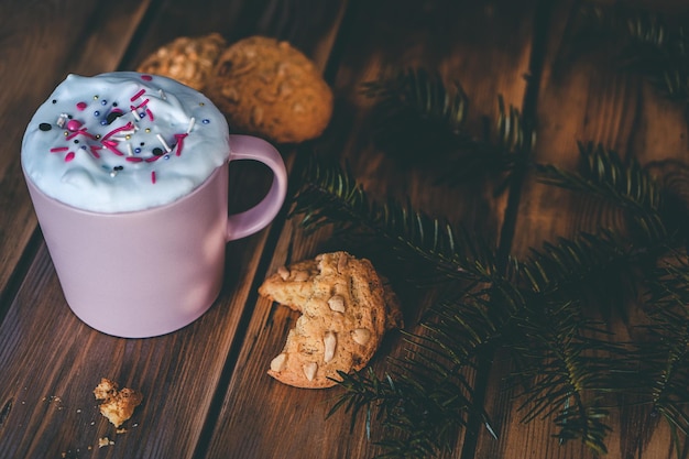 Weihnachtsgetränk mit hausgemachten Keksen auf einem Holztisch