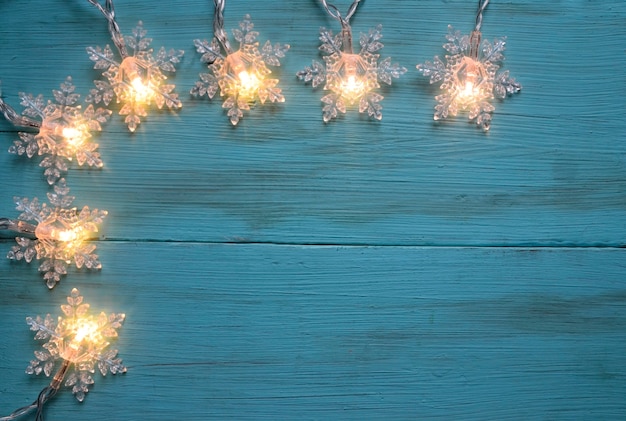 Foto weihnachtsgirlande lichter grenze auf einem blauen holztisch winter festliche dekoration mit kopie raum