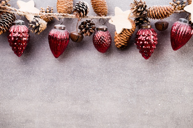 Weihnachtsgirlande mit roter Kugel und grauem Hintergrund.