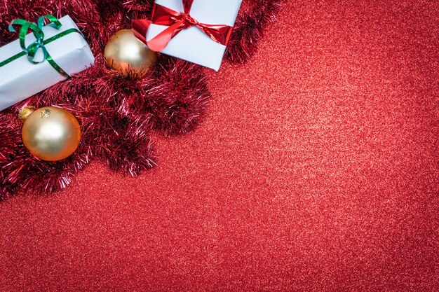 Weihnachtsglänzend roter Hintergrund mit festlichen Dekorationen und Kopienraum für Text