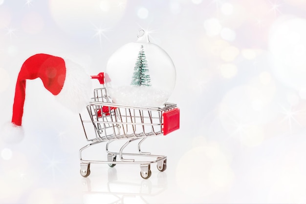 Weihnachtsglaskugel mit einem Miniatur-Weihnachtsbaum Weihnachtsverkauf Supermarktwagen