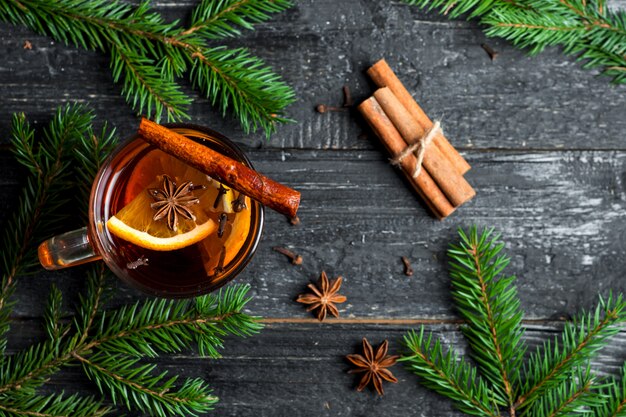 Weihnachtsglühwein in einem becher auf einem holztisch